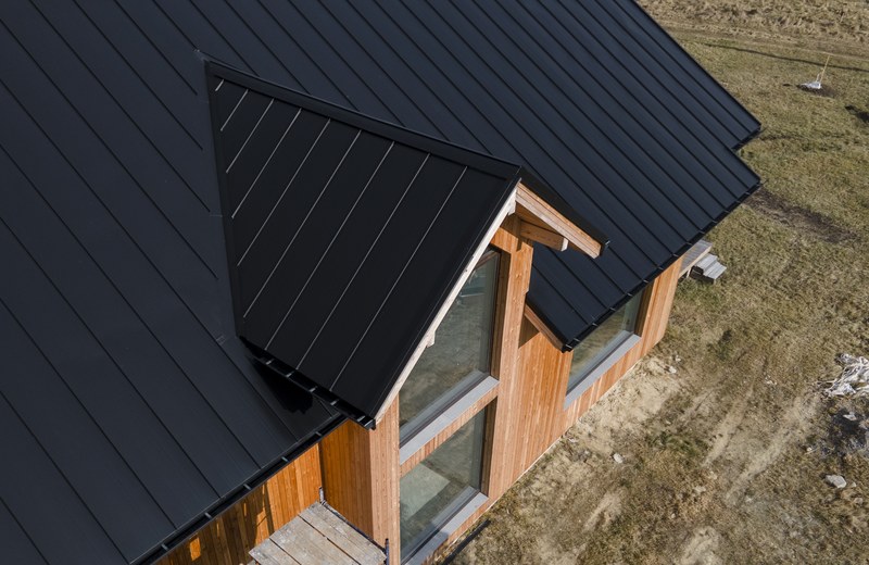 Finished dark standing-seam roof over a dormer
