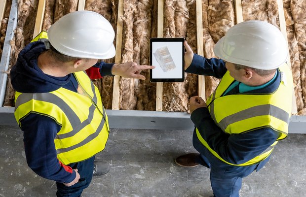 Two inspectors reviewing roof photographs on a tablet